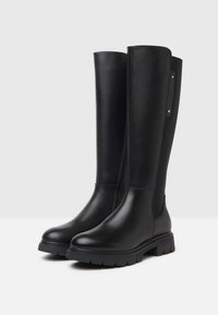 Knöchelhöhe schwarze Lederstiefel mit glatter Textur, runden Zehen, dicken Gummisohlen und seitlichen elastischen Akzenten für Flexibilität.