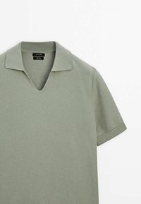 Polo en maille à manches courtes gris-vert clair avec tissu texturé, col en V ouvert et poignets de manches côtelés.