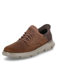 Sneaker in pelle marrone con punta arrotondata, dettagli testurizzati, lacci marroni e suola in gomma grigia imbottita con tasche d'aria rotonde.