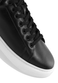 Sneaker in pelle nera con lacci neri piatti, suola in gomma bianca e design minimalista; presenta dettagli di cucitura e chiusura con stringhe.