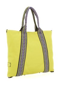 Borsa tote in pelle verde lime con due manici intrecciati a motivo viola, bianco e nero che si estendono lungo i lati su uno sfondo bianco.