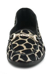Scarpa slip-on nera e beige con motivo leopardato, caratterizzata da un accento metallico sulla parte anteriore e un materiale testurizzato simile a suede.