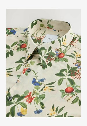 Krátky rukáv košele z krémovej látky so kvetinovým vzorom obsahujúcim zelené listy, červené bobule, modré a žlté kvety a motýle.