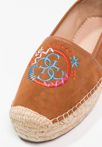 Brune ruskinds espadrille med farverigt broderet design. Naturlig jute reb sål med flettet detalje. Runde tåform.