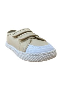 Zapato de lona beige con dos correas de Velcro y una puntera de goma blanca. Presenta una suela de goma blanca texturizada con un patrón de diamante para un mejor agarre.