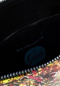 Clutch colorato con motivo e chiusura a zip. Interno foderato in tessuto nero. Include un'etichetta blu che recita "Made in Italy."