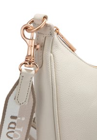 Borsa in pelle beige chiaro con superficie testurizzata, dotata di una chiusura in hardware rosa dorato e di una tracolla intrecciata a contrasto con dettagli stampati.