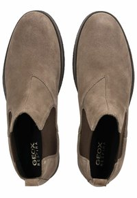 Scarpe slip-on in suede marrone con pannelli elastici laterali, punta rotonda e suola in gomma testurizzata. Presenta il marchio sulla soletta.