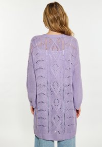 Stickad cardigan i ljus lavendel, med öppen ryggdesign och diamant- samt vertikala mönster, långa ärmar och ribbad nederkant.