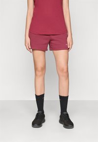 Burgunderfargede treningsshorts med elastisk midje og logodetaljer. Kombinert med sorte sokker og joggesko, med et enkelt design.