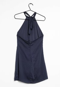 Navyblaues Halterkleid mit einem gebundenen Hals, das über eine subtile Punkttextur und einen verdeckten Reißverschluss im Rücken verfügt und sanft bis zum Saum fällt.