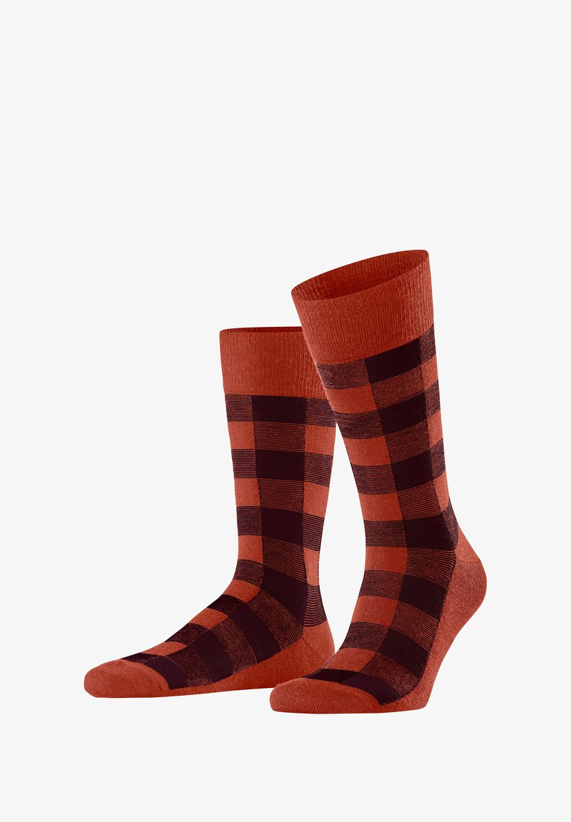 Rot- und schwarzgecheckte Socken aus einem weichen, strukturierten Stoff. Das Design zeigt abwechselnde Quadrate und einen gerippten Bund.