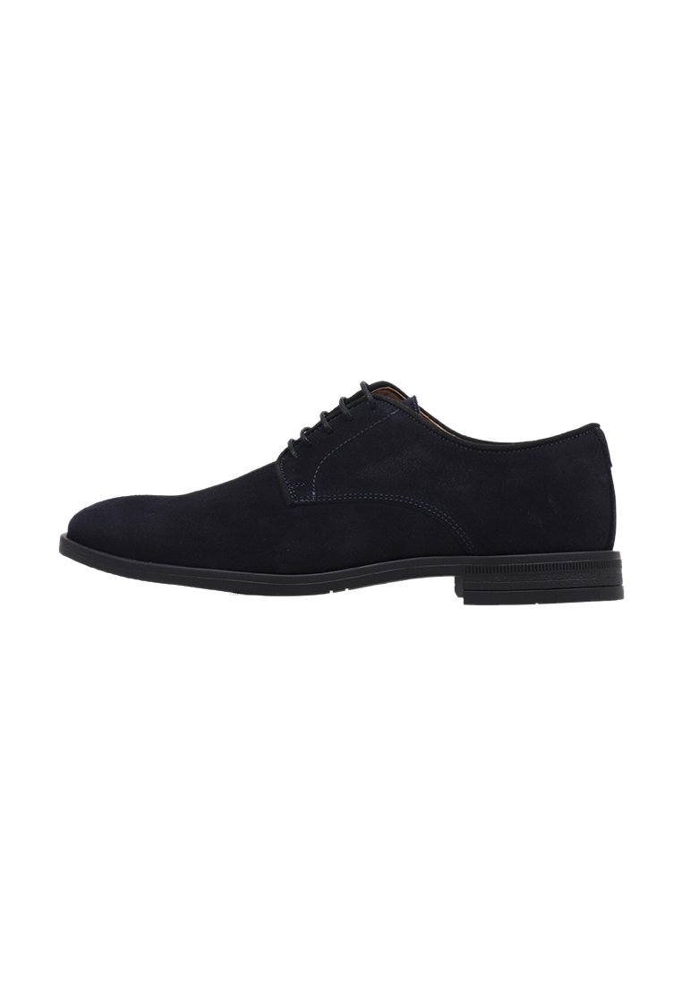 Chaussures en suede noir à lacets avec une finition lisse, un bout arrondi et une semelle en caoutchouc plate. Caractérisées par des coutures minimales et un design classique.