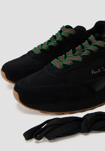 Sneaker in suede nera con lacci verdi e marroni, suola in gomma marrone e lettering dorato sul lato. Lacci neri aggiuntivi inclusi.