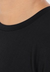Sort bomulds t-shirt med rund hals og ribbet halsudskæring. Materialet ser glat ud med en ensartet tekstur og præsenterer et simpelt design.