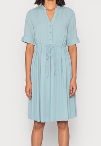 Ljusblå, kortärmad klänning med knapplist, insydd midja, texturerad tyg och en flödande kjol i knälängd.