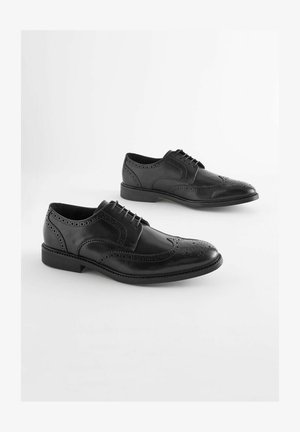 Black leather dress shoes with brogue detailing, featuring a rounded toe, laces, and a low heel. Smooth texture with perforated accents.
