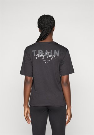 Schwarzes Sport-T-Shirt mit kurzen Ärmeln, auf dem Rücken mit dem Text "TRAIN Pretty Tough" in Grau und Weiß bedruckt. Glatte Stofftextur.