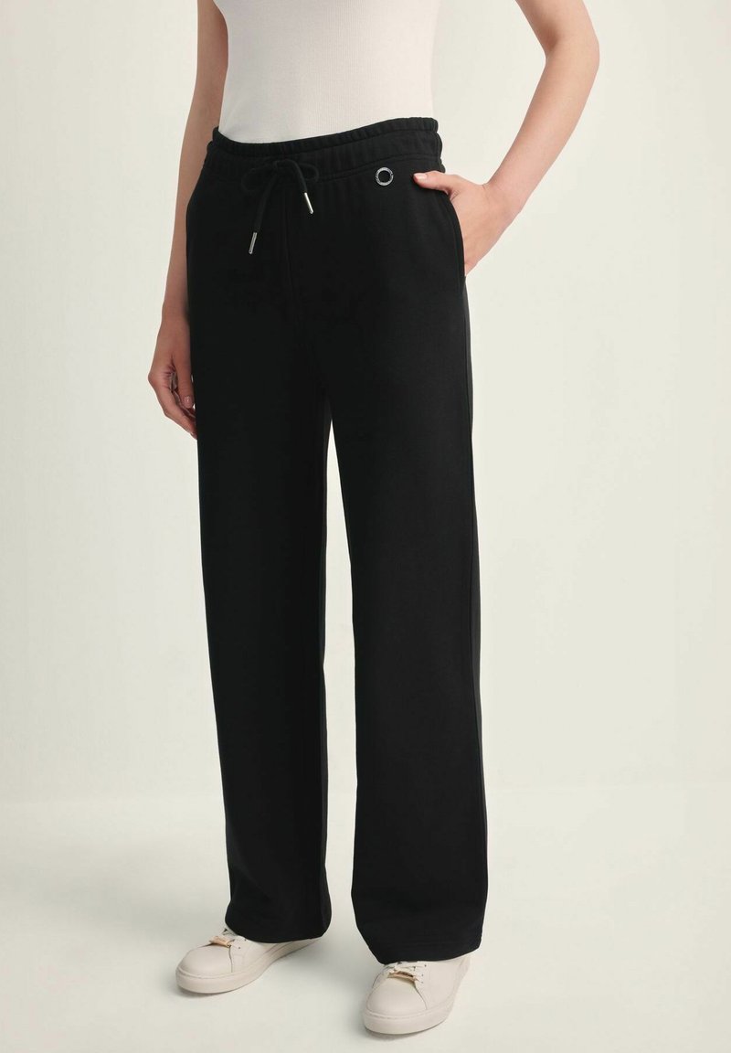 Czarne, szerokie spodnie dresowe z elastycznym paskiem w talii, regulowanym sznurkiem i bocznymi kieszeniami. Gładka tekstura, casualowy styl, brak wzorów.