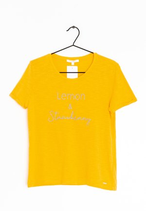 T-shirt jaune à manches courtes avec un col rond, portant le texte "Lemon & Strawberry" en lettres argentées scintillantes.