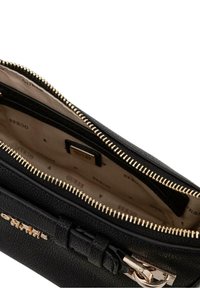 Borsa a tracolla in pelle nera con chiusura zip, hardware dorato e interno beige con un motivo a logo ripetuto.