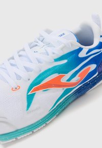 Zapatilla deportiva blanca con un diseño degradado en verde azulado y azul, con acentos naranjas y tela texturizada. Los cordones son blancos y cuenta con un collar acolchado.
