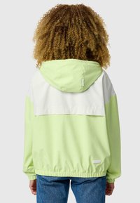 Veste à capuche vert clair avec un panneau supérieur blanc, ourlet et poignets élastiqués, arborant une petite étiquette de logo en bas à droite.
