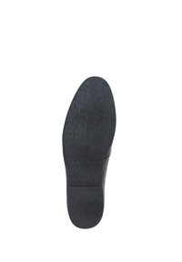 Černá podrážka boty s hladkým, texturovaným povrchem. Lehce zaoblený tvar s plochým podpatkem. Minimální design, s diskrétním brandingem podél okraje.