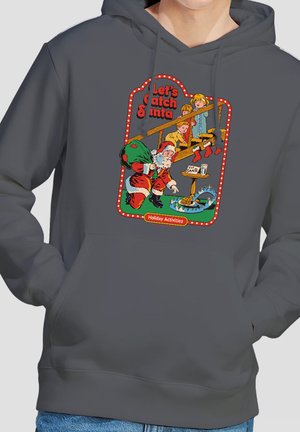 Children watch from a staircase as Santa reaches for cookies set as bait in a bear trap on a gray hoodie with "Let's Catch Santa" text.