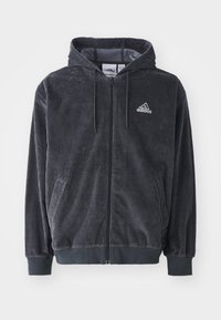 Svart kordfluwel Adidas zip-up hoodie med dragsko, ribbade muddar och nederkant samt broderad logotyp på vänster bröst.
