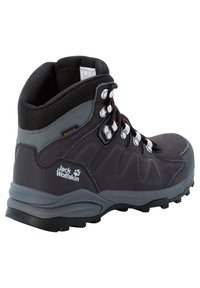 Schwarzer und grauer Jack Wolfskin Wanderschuh mit gepolstertem Kragen, Metallösen, rot akzentuierten Schnürsenkeln und robustem Profil für den Außeneinsatz.