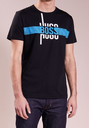 T-shirt en coton noir avec une rayure horizontale bleue portant le mot "BOSS" en lettres blanches en gras et un col rond.