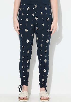 Leggings blu navy realizzati in tessuto elasticizzato, con un motivo geometrico color crema, forma aderente e caviglie arricciate con lacci.