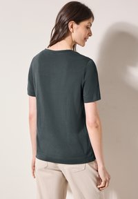 Krátký rukáv, tmavě šedé bavlněné tričko s kulatým výstřihem. Zadní strana má hladkou texturu a jednoduchý design bez ozdob.