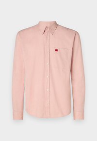 Hellrosa Langarmhemd aus Leinen mit einem Button-down-Kragen, einer Brusttasche und einem kleinen roten Etikett an der Tasche.