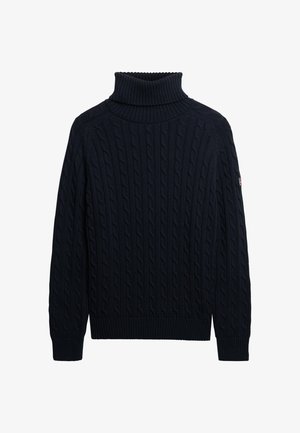 Marineblå kabelstrikket turtleneck sweater med ribbede manchetter, kant og krave, der har et lille patch på venstre ærme.