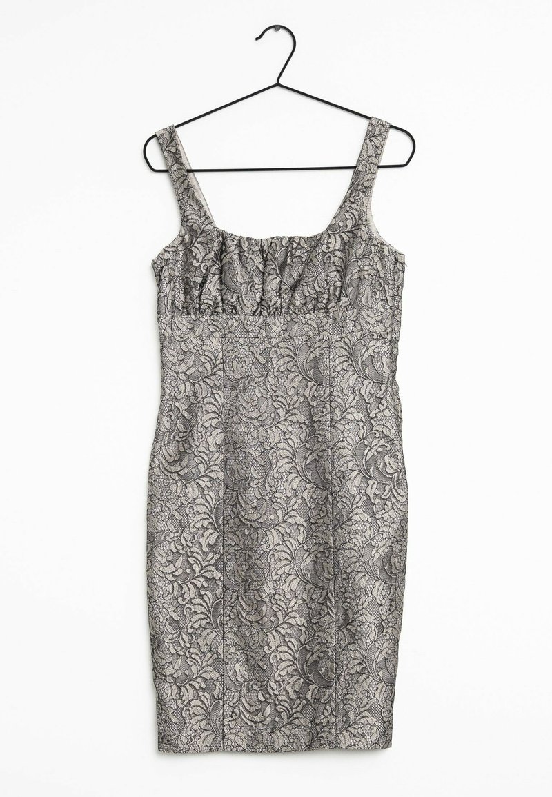 Robe grise sans manches avec motif en dentelle florale noire, suspendue sur un cintre métallique noir sur fond blanc.