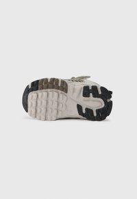 Athletischer Schuhsohle mit einer strukturierten Gummibasis. Verfügt über unterschiedliche Griffmuster in Schwarz, Grau und Beige. Verstärkte Kanten für Langlebigkeit.