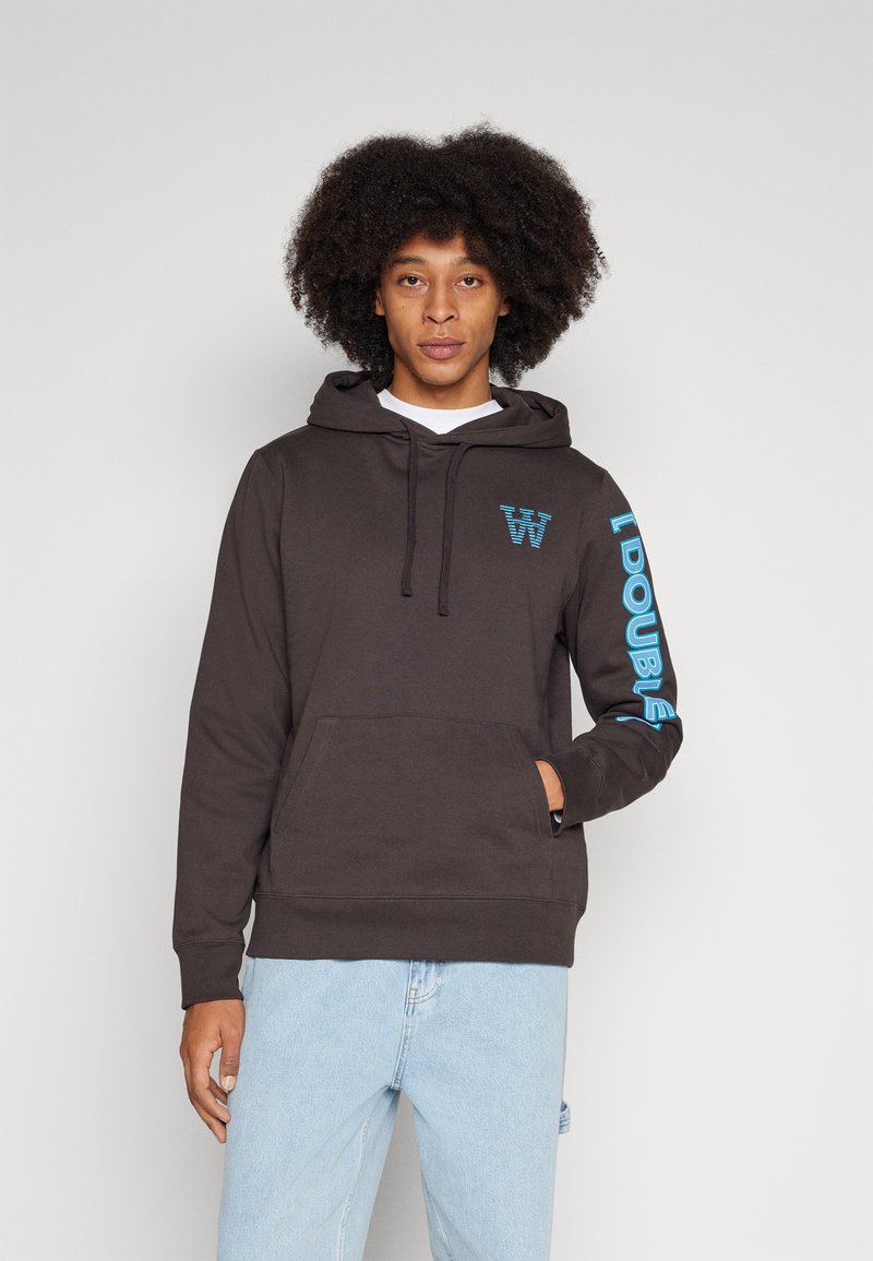 Dark brown hoodie with kangaroo pocket; features blue logo on chest and vertical text on sleeve; cotton blend fabric with smooth texture.