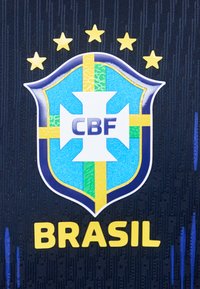 Λογότυπο της ποδοσφαιρικής ομάδας της Βραζιλίας με πέντε αστέρια από πάνω και την επιγραφή «BRASIL» με κίτρινο χρώμα σε σκουρόχρωμο μπλε φόντο με υφή υφάσματος.