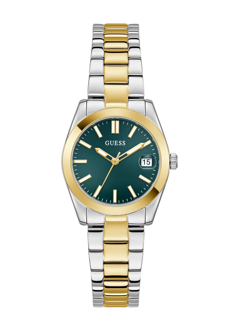 Montre Guess avec un cadran rond vert foncé, lunette dorée, bracelet en acier inoxydable argenté et doré, affichage de la date et index horaires minimalistes.