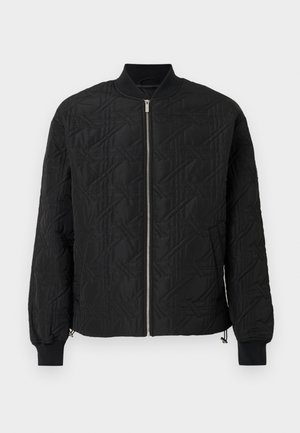 Veste bomber noire matelassée avec fermeture éclair à l'avant, col et poignets côtelés, et poches latérales sur fond blanc.