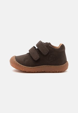 Scarpa marrone per bambino piccolo con doppie cinghie in velcro e suola in gomma texturizzata, progettata per comodità e facile allacciatura.