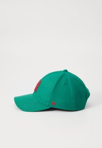 Grønn bomull baseballcaps med buet brem, rød broderte logo foran, og matchende rød detalj på siden. Har ventilasjonshull.