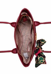 Kabelka z burgundské kůže se zlatým kováním. Vnitřní část je vybavena vzorovanou podšívkou a akcentem v podobě hedvábného šátku v zelené, červené a černé barvě.