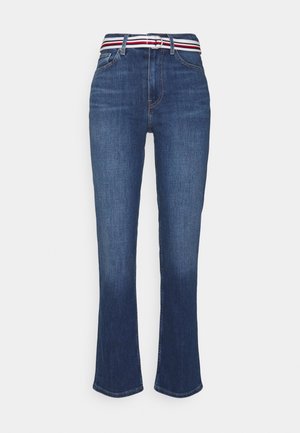 Jean bootcut en denim bleu avec poches avant et ceinture en tissu rayée blanc, marine et rouge, équipée d'une boucle à double anneau.