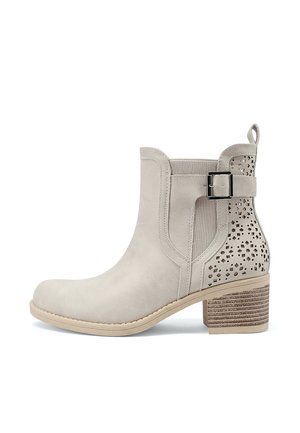 Stivaletto beige con tacco a blocco, cinturino laterale con fibbia, pannello elastico e motivo di ritagli geometrici sul retro.