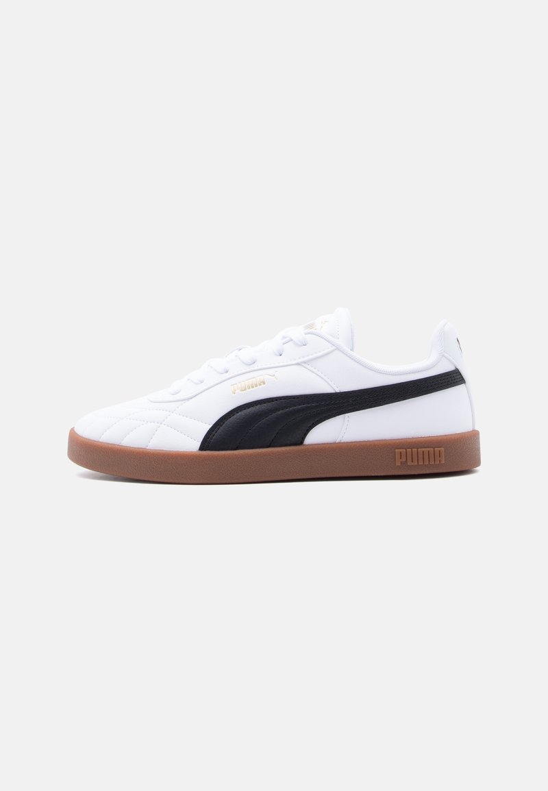 Baskets blanches Puma avec bande latérale noire et semelle marron, vues de profil sur un fond gris clair.