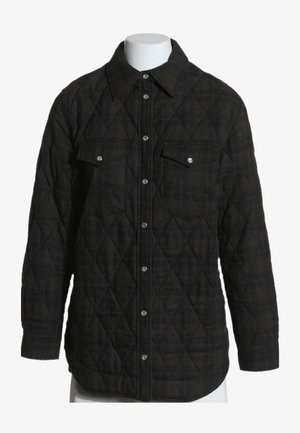 Chaqueta negra acolchada de manga larga con botones a presión plateados, dos bolsillos con solapa en el pecho y un cuello puntiagudo sobre un maniquí blanco.