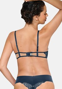 Ensemble de lingerie bleu marine avec un dos en dentelle transparente, des bretelles réglables et une fermeture à crochets. Les culottes avec une bordure en dentelle complètent le design.
